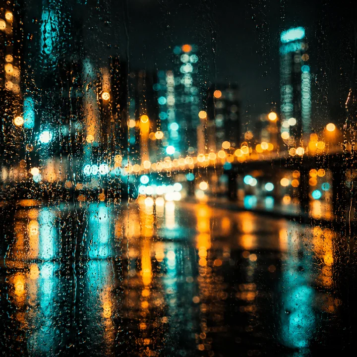 City lights reflected through rain